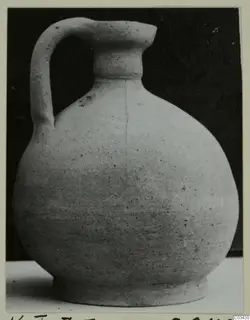 Pot with a single handle from Kountoura Trachonia, photographed against a dark background.