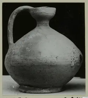 Pottery jug with a single strap handle and a wide, rounded body.
