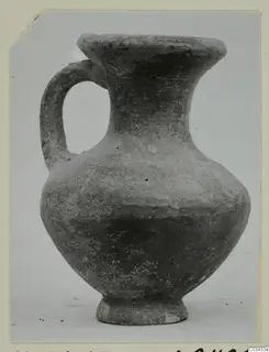 Pottery jug with one handle, a flared mouth and a rounded body, photographed against a pale background.