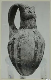 White Painted IV-V pottery jug with a strap handle and dark vertical bands on the body