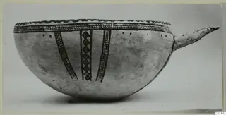 Pottery White Slip Ware bowl with dark painted bands and a long projecting handle