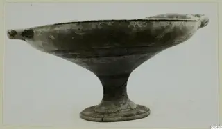 Pottery bowl-jar on a stem foot, with two small handles at the rim, shown against a light background.