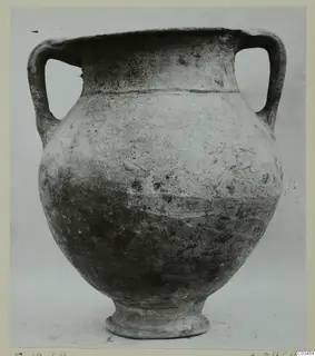 Plain white wheel-made pottery jar with two loop handles and a footed base, photographed against a plain grey background.