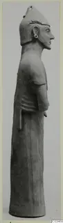Terracotta standing figure in profile facing right, wearing a tall pointed headdress, from Ayia Irini