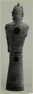 Terracotta figure with a ribbed upper body, arms at the sides, a crest-like top to the head and a tall tapering base.