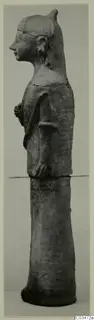 Terracotta statue of a standing female figure in profile, facing left, on a tall cylindrical base.