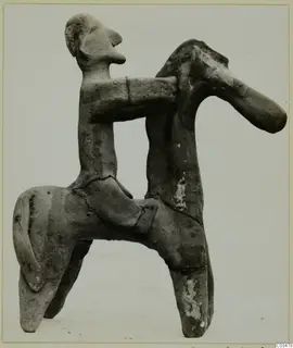 Terracotta figurine of a human figure seated on a four-legged animal