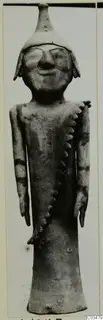Terracotta figurine of a standing figure with a tall conical headdress and a notched applied strip across the body