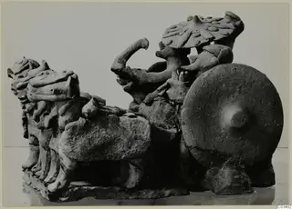 Terracotta group of animal heads and a figure with a large round shield, possibly a chariot with horses