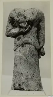 Limestone sculpture of a head on a tall, tapering base, with a long nose in profile