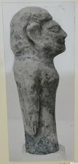 Limestone figure in side profile facing right, with a band around the neck