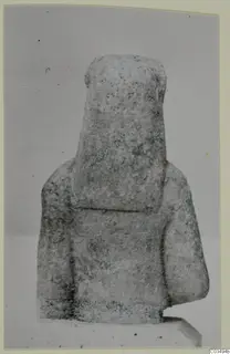 Limestone Neo-Cypriote statue of a block-like figure with a squared head and shoulders, seen from the front.
