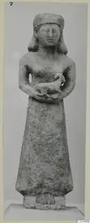 Limestone Neo-Cypriote statue of a standing female figure holding a small animal against her chest