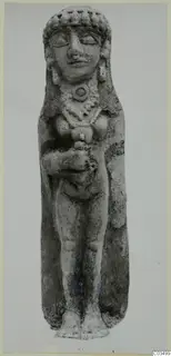 Standing terracotta figurine of a female figure with a tall headdress, necklace and arms bent at the chest.