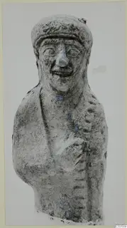 Terracotta figurine of a smiling figure in a cap, with traces of blue paint on the face and chest