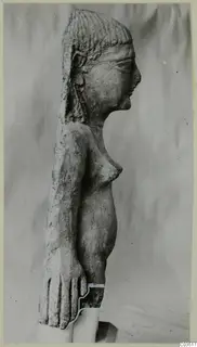Terracotta figurine of a standing female figure, shown in profile against a grey cloth