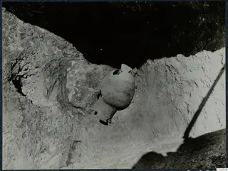 Pottery vessel in situ during excavation at Stylli, seen in a rock-cut trench