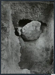 Large stone blocking the doorway of Tomb 8 at Stylli, seen from within a trench