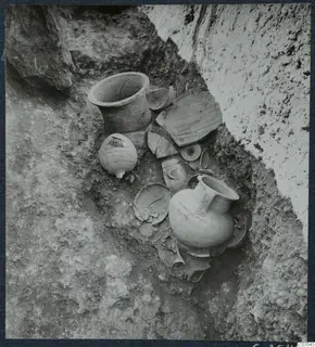 Pottery vessels and loose sherds lying in situ in an excavated trench at Stylli