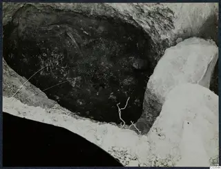 Excavation pit at Stylli with large pale stones at its edge