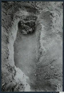Excavation trench at Stylli with a cluster of stones in a recess at the far end
