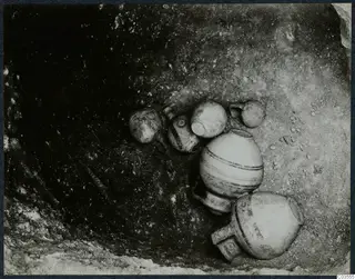 Several pottery vessels lying in situ in an excavated hollow at Stylli.