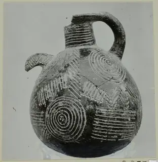 Pottery Red Polished II jug from Lapithos, with a beak spout, loop handle and pale concentric circles and chevrons