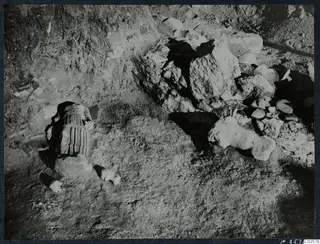 Finds in situ at Cholades, Soli: a headless draped stone statue and fragments lying in excavated ground beside a rubble heap.