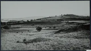 Field view of the acropolis at Soli from the north-west, with a hill, cultivated fields and scattered trees