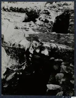 Excavation trench at Soli with exposed stone walls and a flat slab across the middle