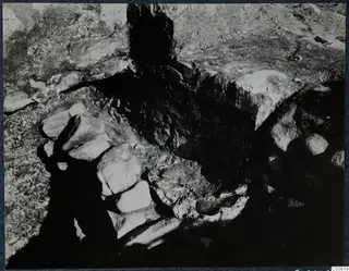 Excavation at Soli, Cholades temples: a stone construction of large blocks set against cut rock and dark soil.