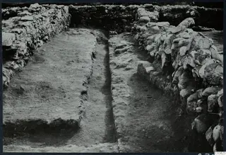 Excavation at Soli showing stone walls running along both sides of a trench with earthen surfaces between them.
