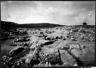 Excavated stone foundations of the Cholades temples A-B at Soli, with hills and a single tree behind the site.