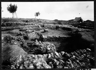Excavation at Soli, Cholades Temples A-B, with stone walls, a tent and trees