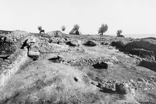 Excavated stone walls of Temple C at Cholades, Soli, with a tent and a donkey in the background