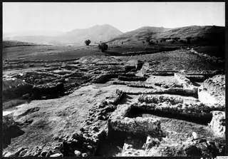 Excavated stone wall foundations at Cholades, Soli, with hills and a mountain behind