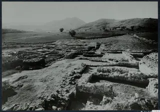 Excavated stone wall foundations at Cholades, Soli, with hills and scattered trees beyond