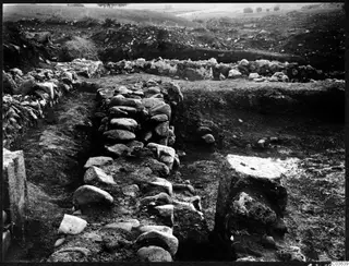 Excavated stone walls at the Cholades temples A-B at Soli, with trees on the hills behind