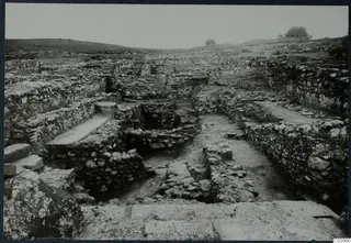 Excavated stone walls and foundations at Soli, Cholades temples, seen across a dug area with low hills behind