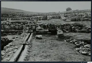 Excavated stone walls and a stone-lined channel at the Cholades temples A-B at Soli