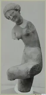 Marble statue of a female figure with her head tilted to one side, arms broken off, standing on a white plaster base