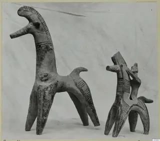 Two terracotta animal figurines with dark painted stripes on their necks, bodies and legs.