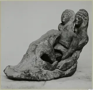 Terracotta figurine group of two heads and bodies joined to a rounded base with an opening