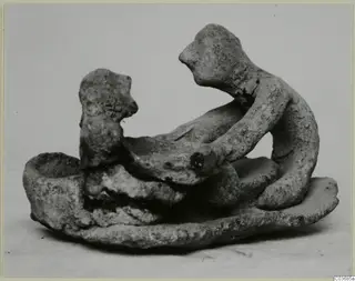 Terracotta group of two small figures on an oval base, beside a cup-shaped hollow.