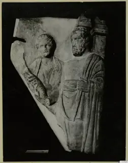 Relief fragment of two standing figures carved in pale stone, one of them bearded