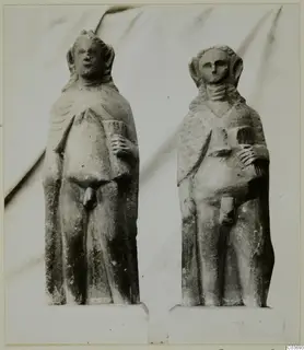 Two limestone standing figurines on plinths, placed side by side.