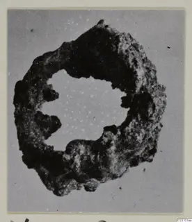 Corroded bronze ring, a personal adornment from the Vouni tombs, shown face-on on a mounted photograph card