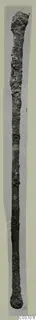 Long corroded bronze implement with a swollen top end and rounded knob at the bottom, from Vouni.