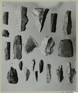 Worked stone pieces and flakes from Kythrea, laid out in rows on a grey background.