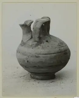 Pottery bowl-jar with two upright spouts, shown alone on a pale surface
